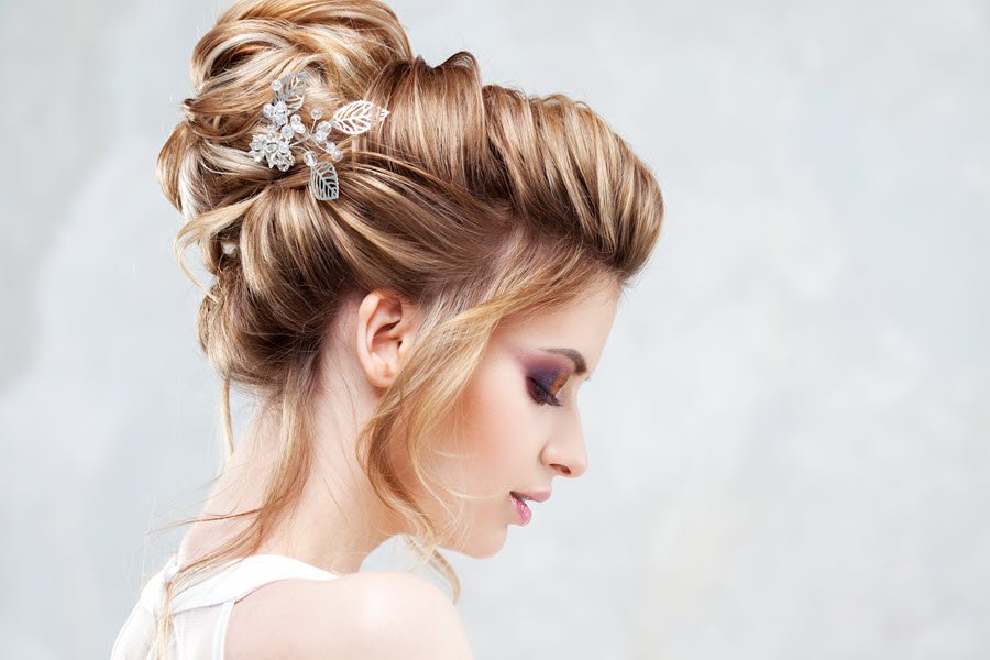 Bride wearing an elegant curled updo with decorative hair accessories for a formal occasion.