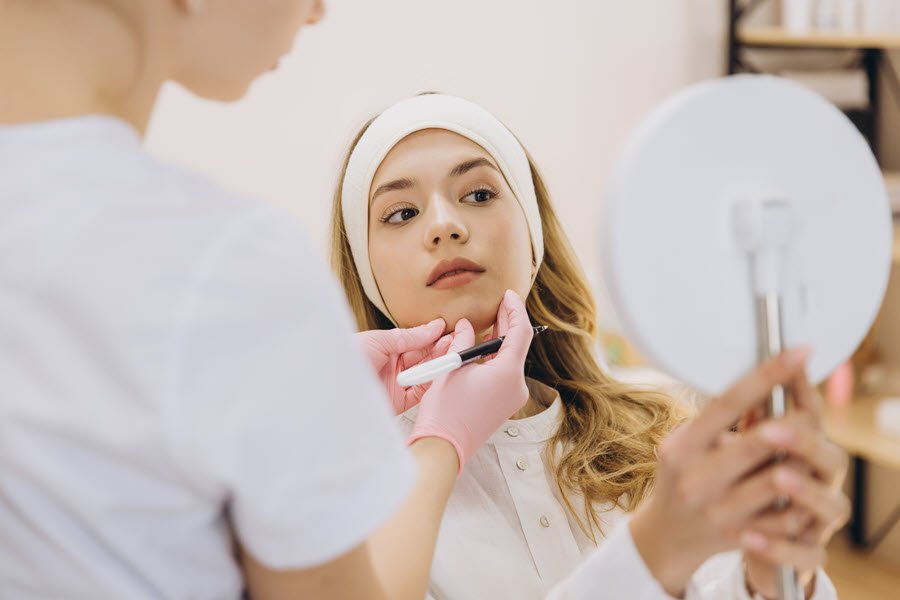 Esthetician examining a client’s skin during a professional skincare consultation and analysis.