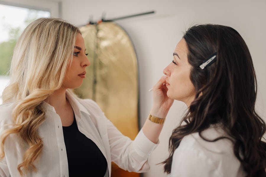 Makeup artist applying makeup to a client during a professional beauty appointment.